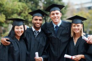 Smiling new grads celebrating graduation together with diplomas and bright career ambitions.